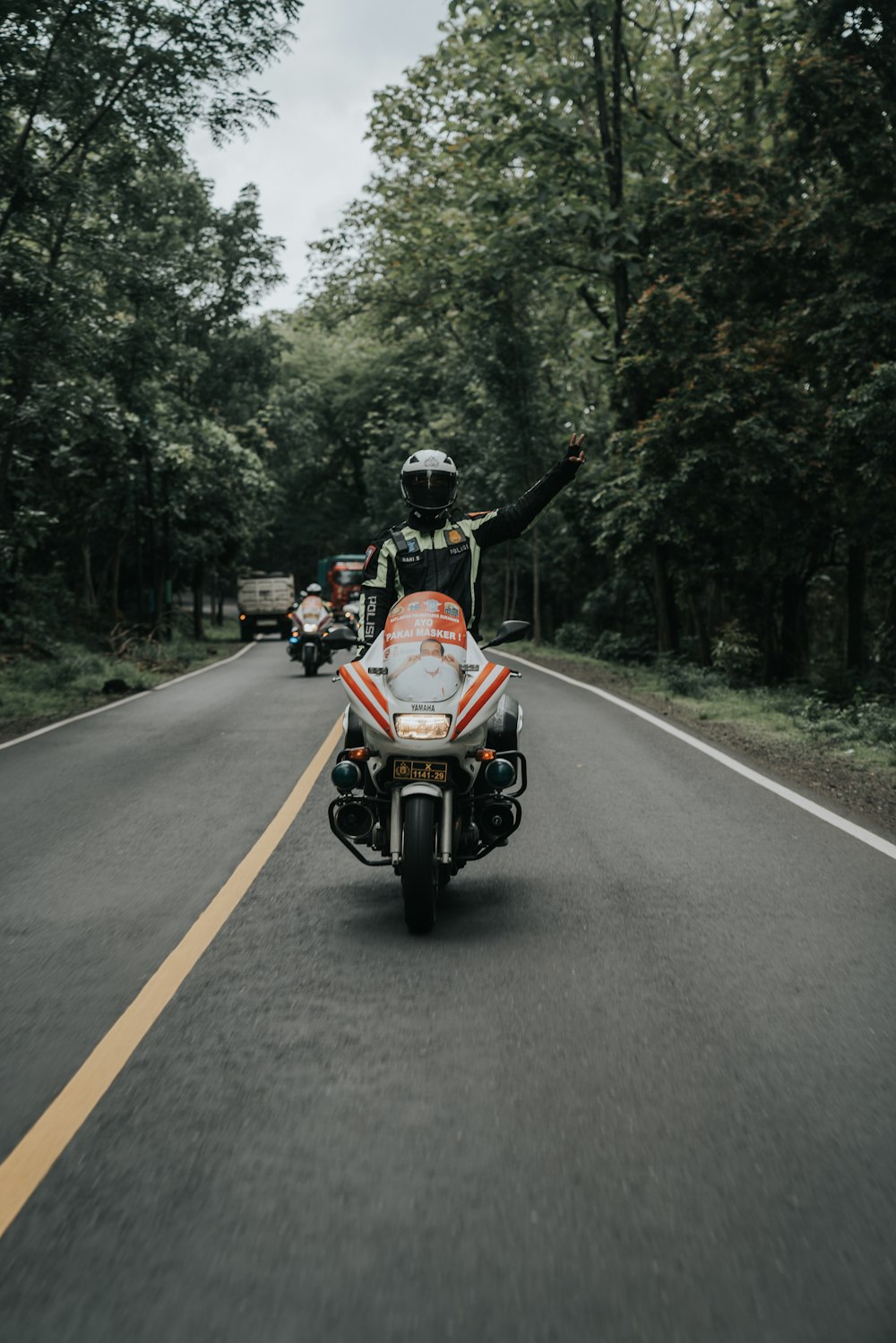 man in red and black motorcycle on road during daytime