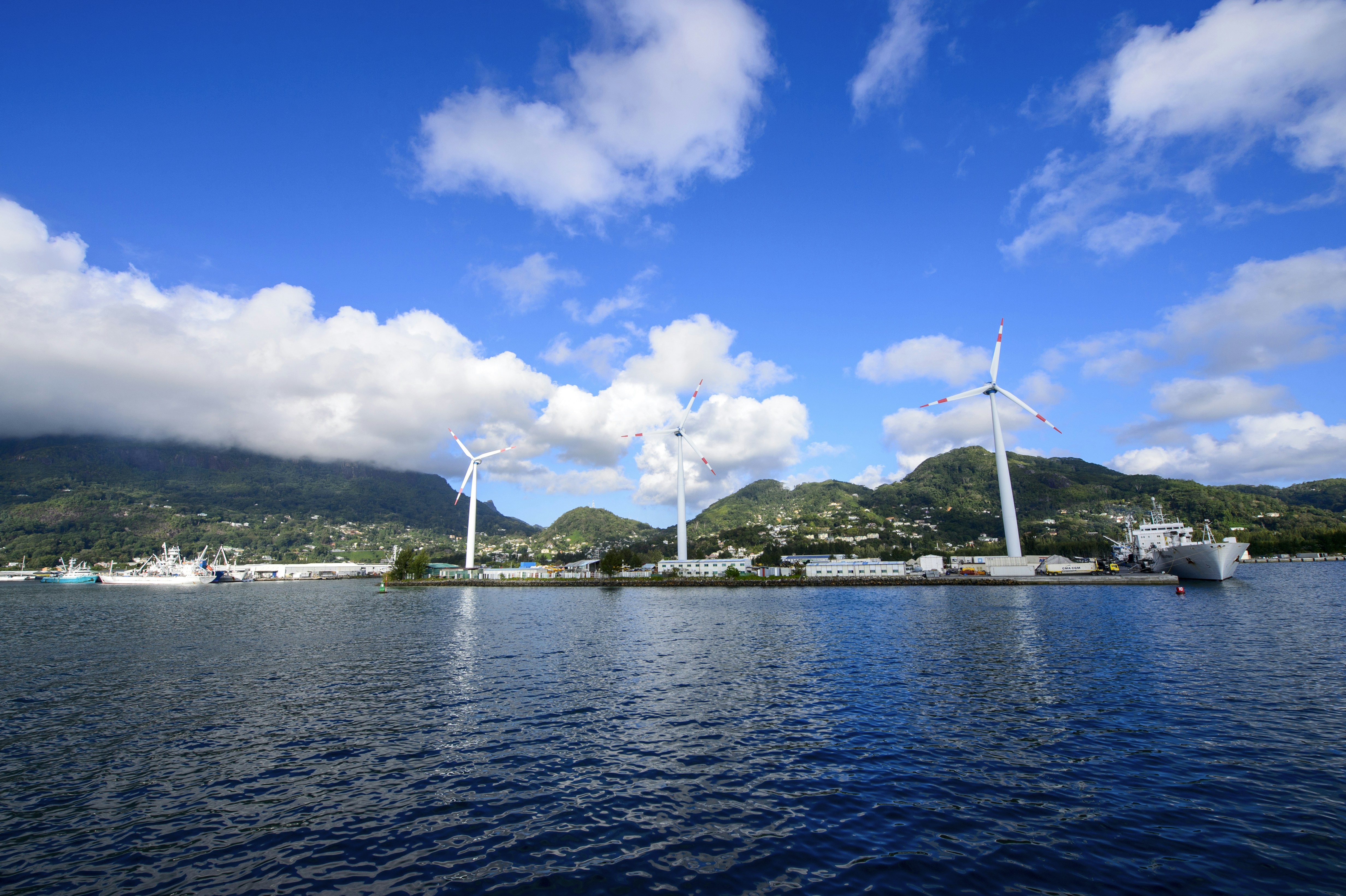 white sail boat on sea under blue sky and white clouds during daytime
