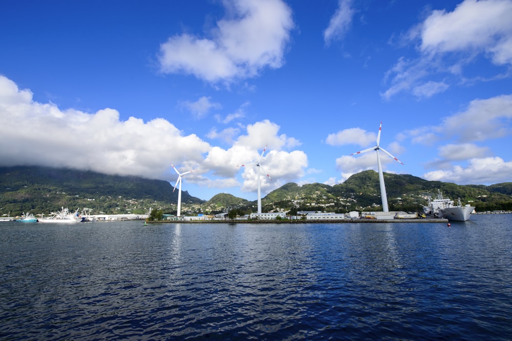 white sail boat on sea under blue sky and white clouds during daytime