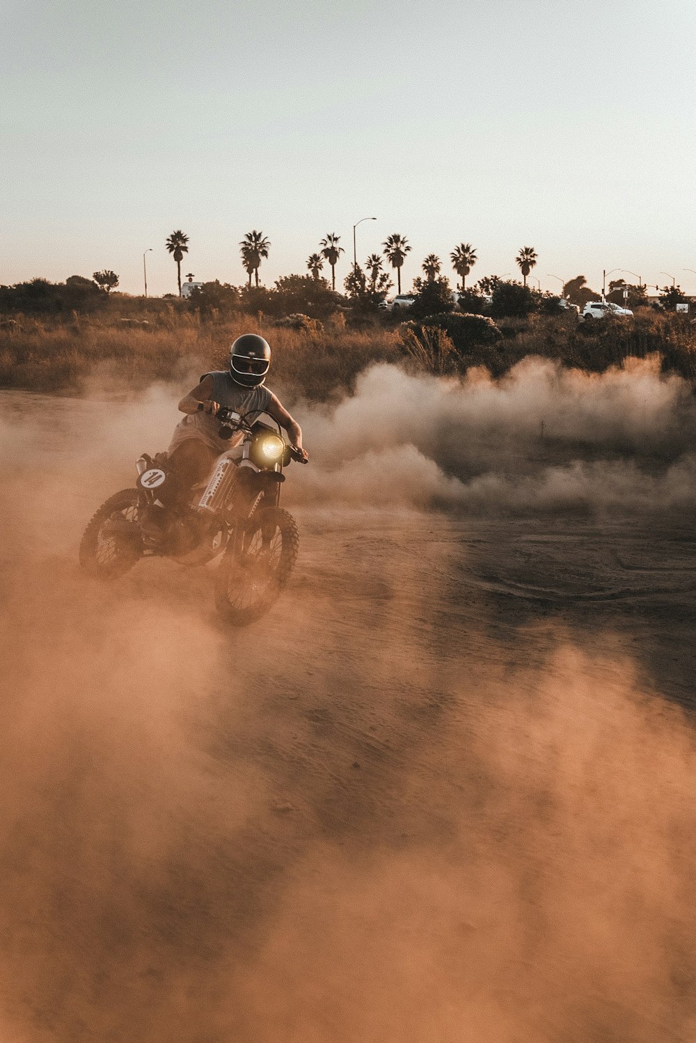 homme conduisant une moto sur un terrain brun pendant la journée