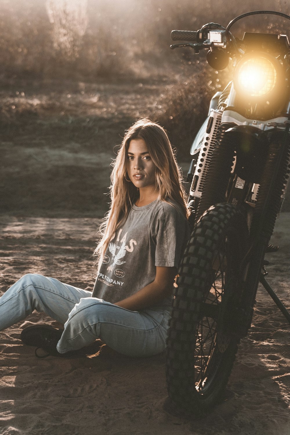 woman in gray crew neck t-shirt and blue denim jeans sitting on black metal chair