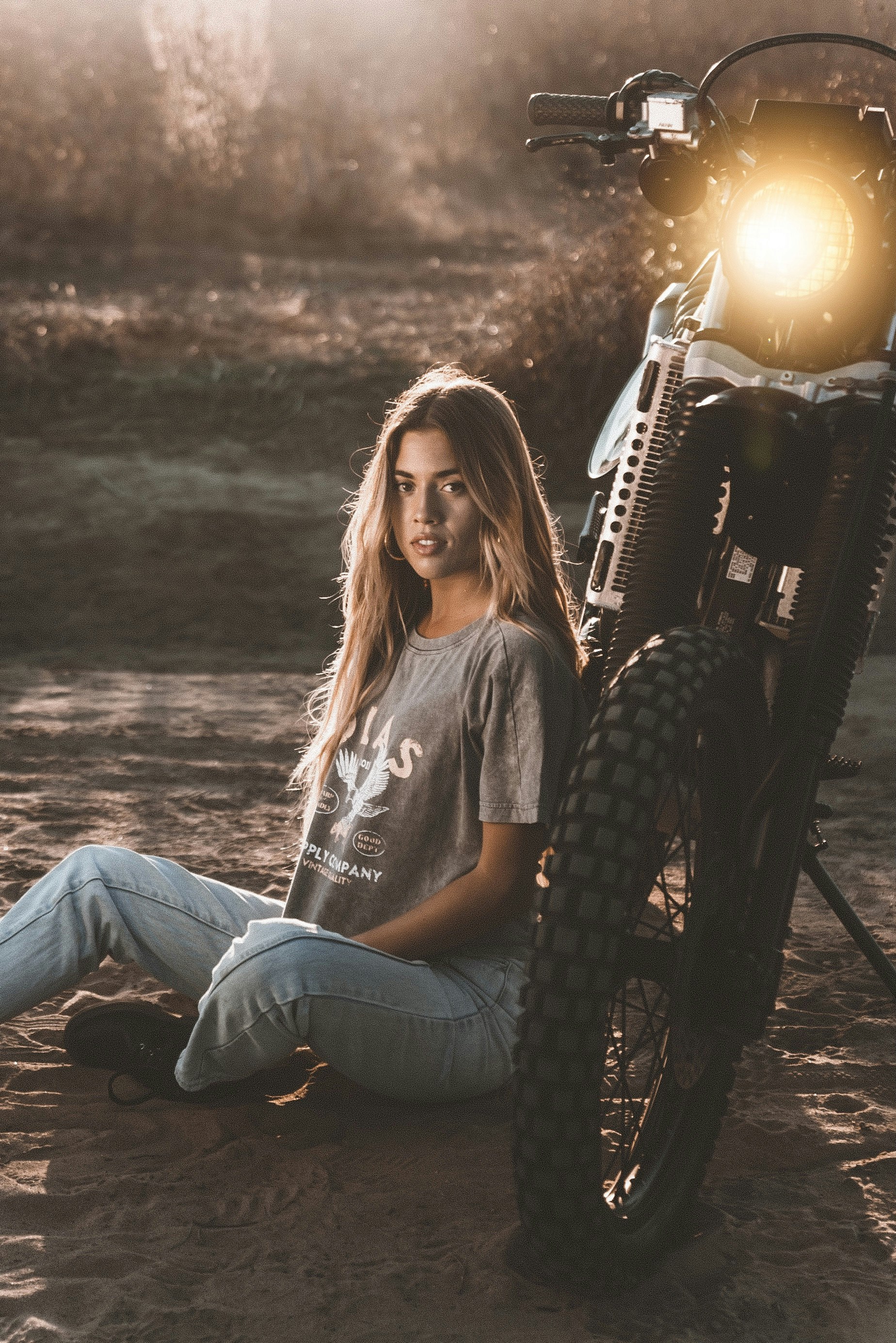 woman in gray crew neck t-shirt and blue denim jeans sitting on black metal chair
