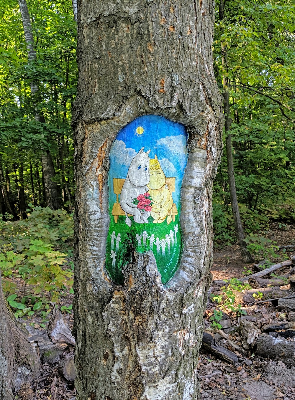 blue and green bird graffiti on brown tree trunk