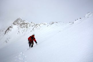 2 person walking on snow covered ground during daytime