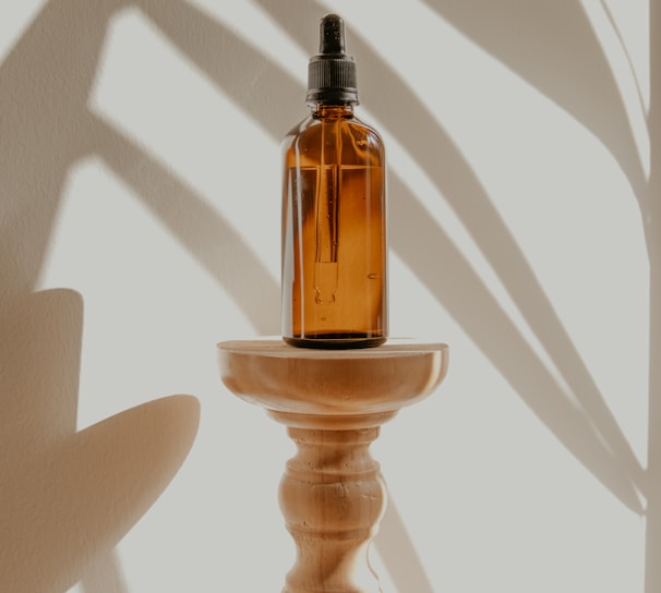 gold and black bottle on white wooden table