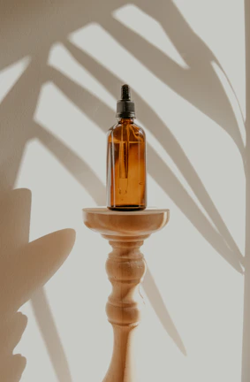 gold and black bottle on white wooden table