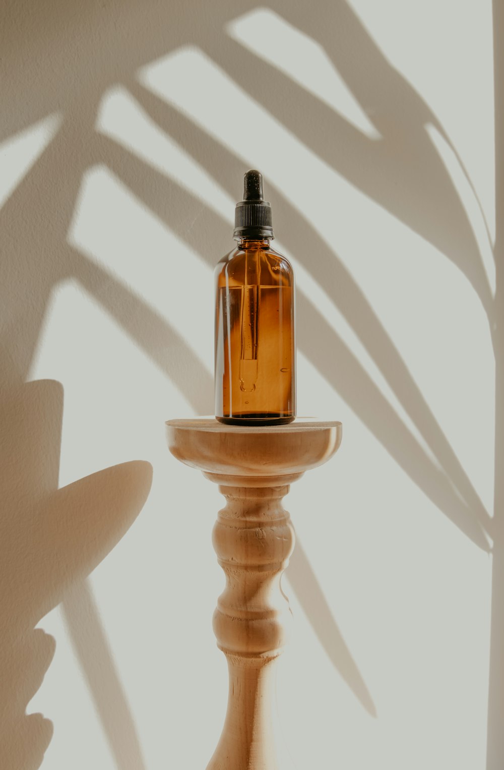 bouteille dorée et noire sur table en bois blanc