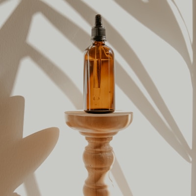 gold and black bottle on white wooden table