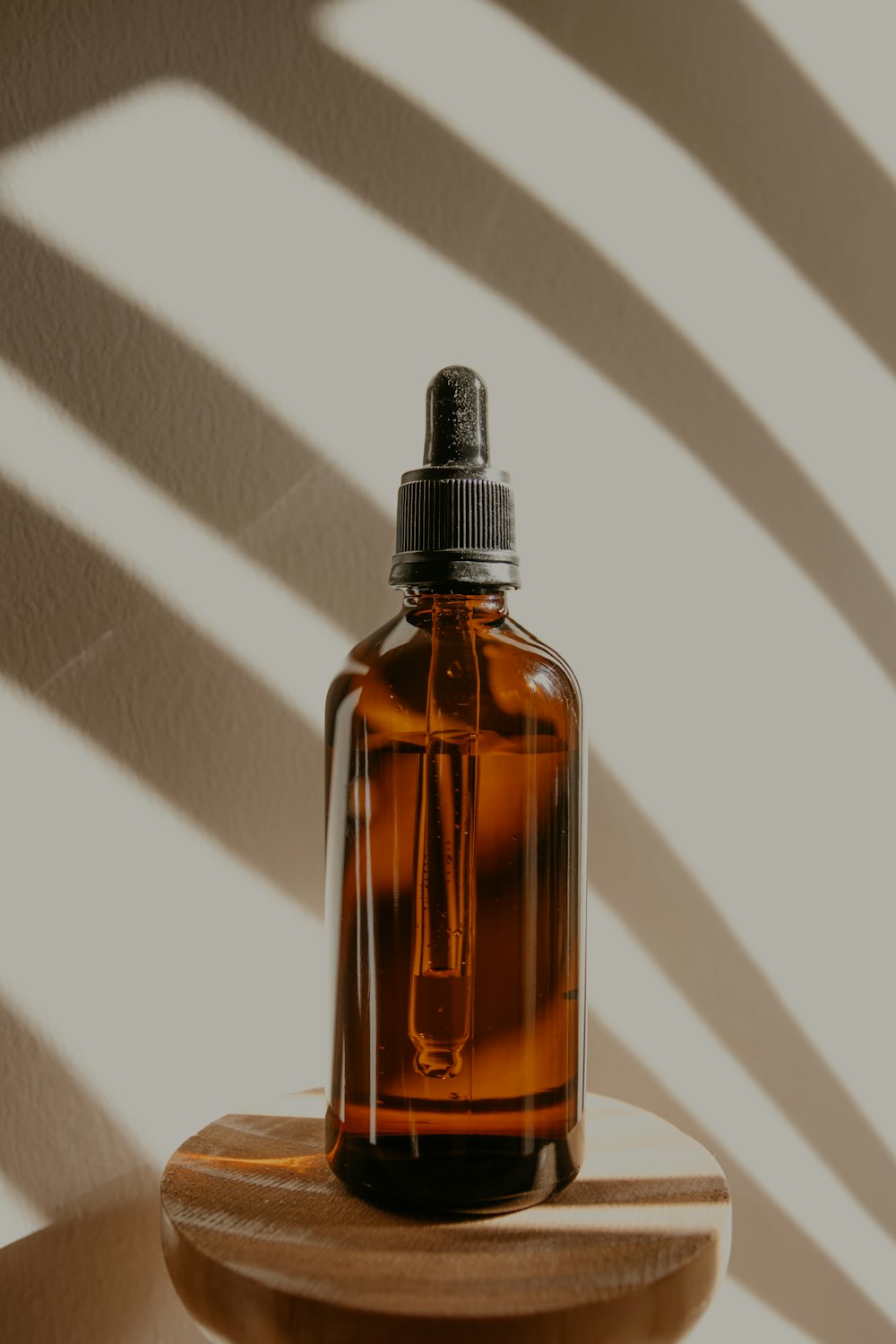 Botella de vidrio marrón sobre mesa blanca