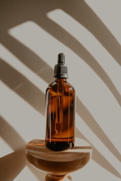 clear glass bottle on brown wooden table