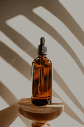 clear glass bottle on brown wooden table
