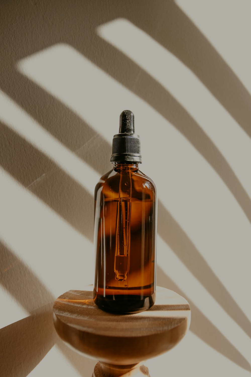 滴管瓶配木色底座，呈現小瓶香氛用品的外觀與收納情境，同類用品示意照片（商品示意）