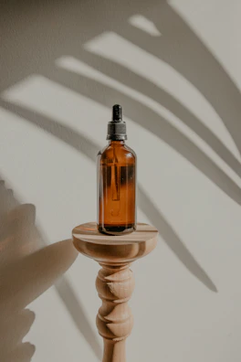 A 20ml essential oil bottle placed on a wooden surface with soft shadows