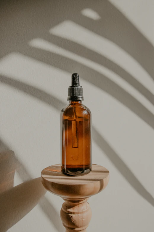 An amber dropper bottle on a wooden stand