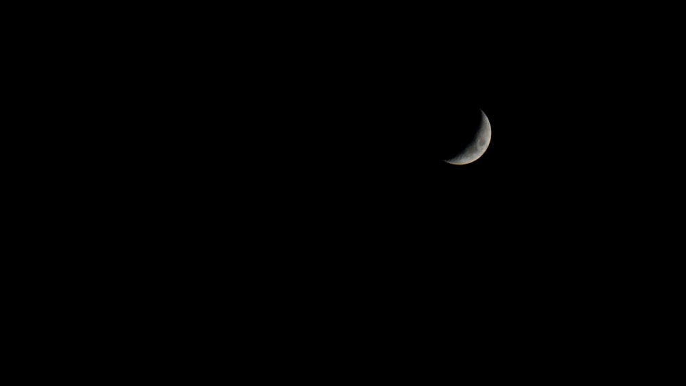 white crescent moon in dark night sky