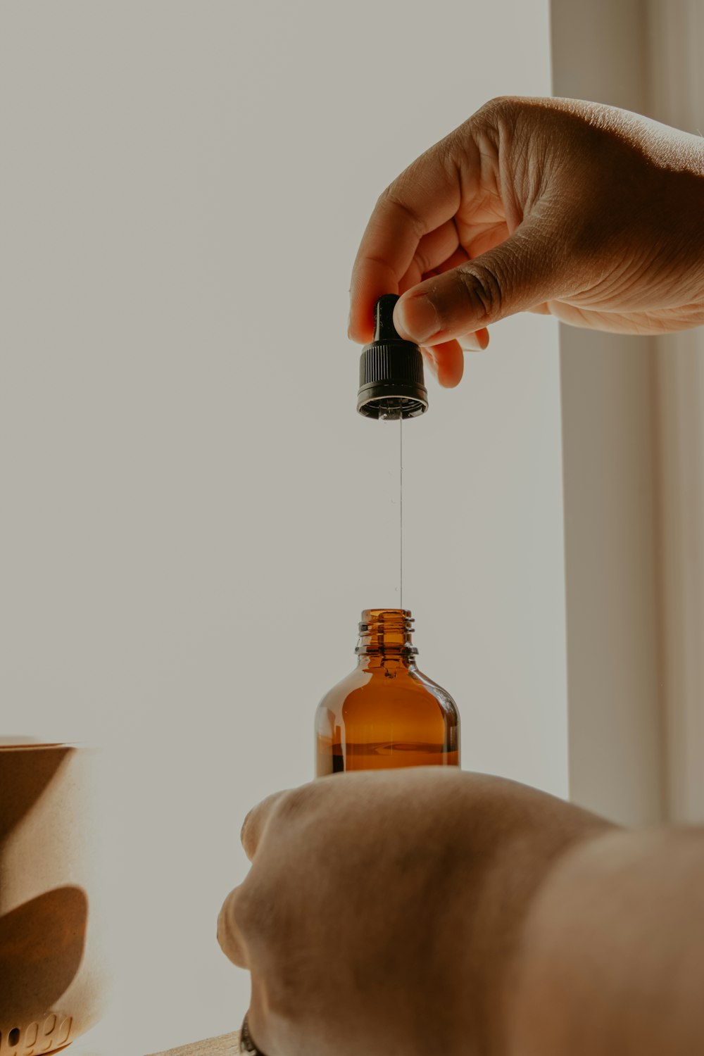 person holding brown glass bottle