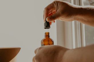 person holding brown glass bottle