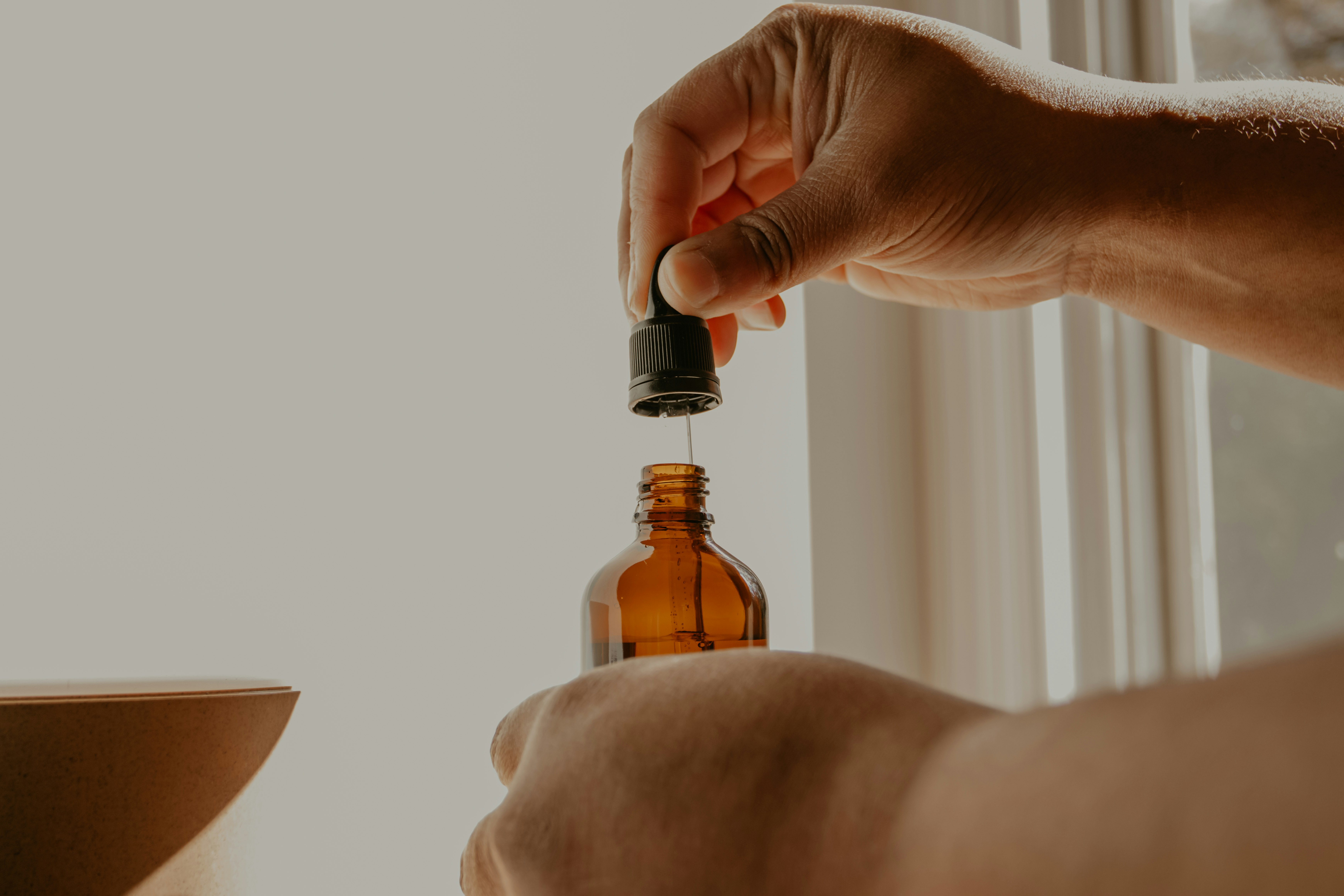 person holding brown glass bottle