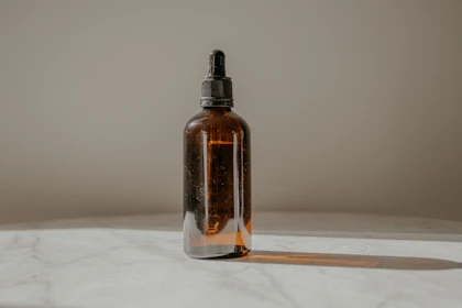 Serum-Flakon aus Braunglas mit Pipette auf Marmor