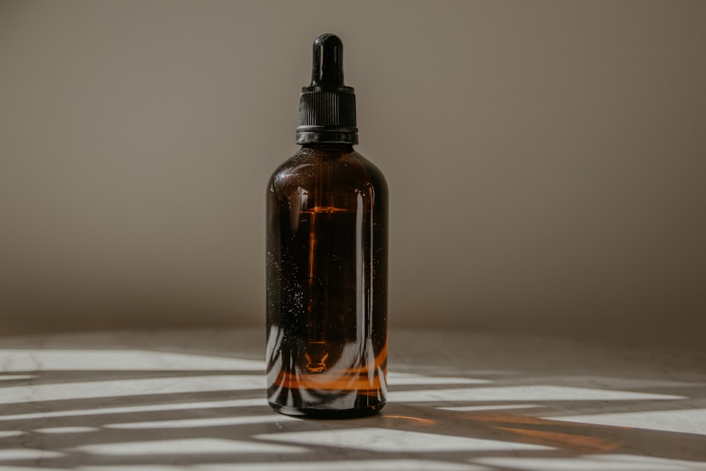 brown glass bottle on white table