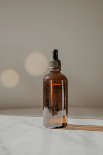 Elegant dropper bottle of essential oil with soft warm lighting