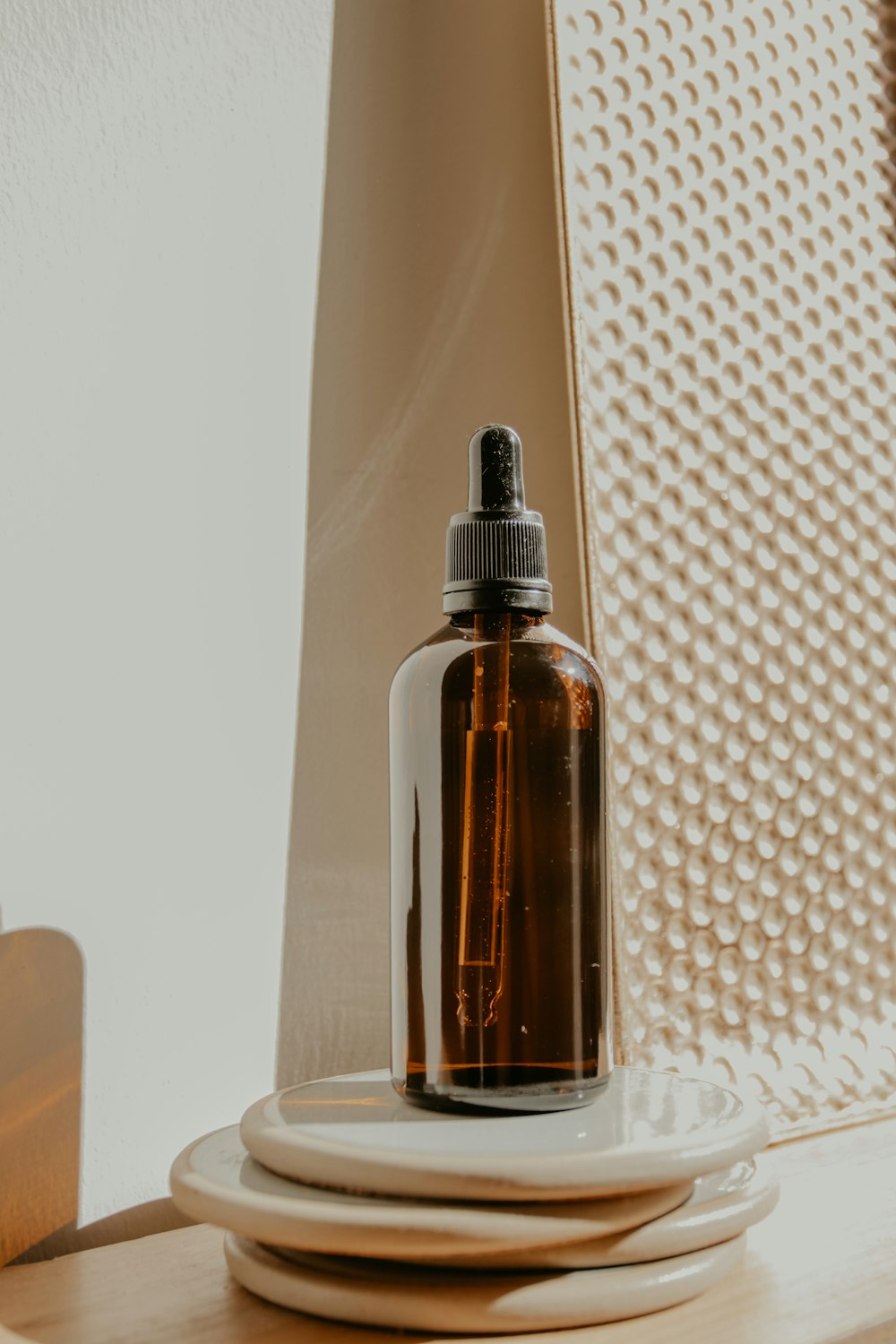 brown glass bottle on white table