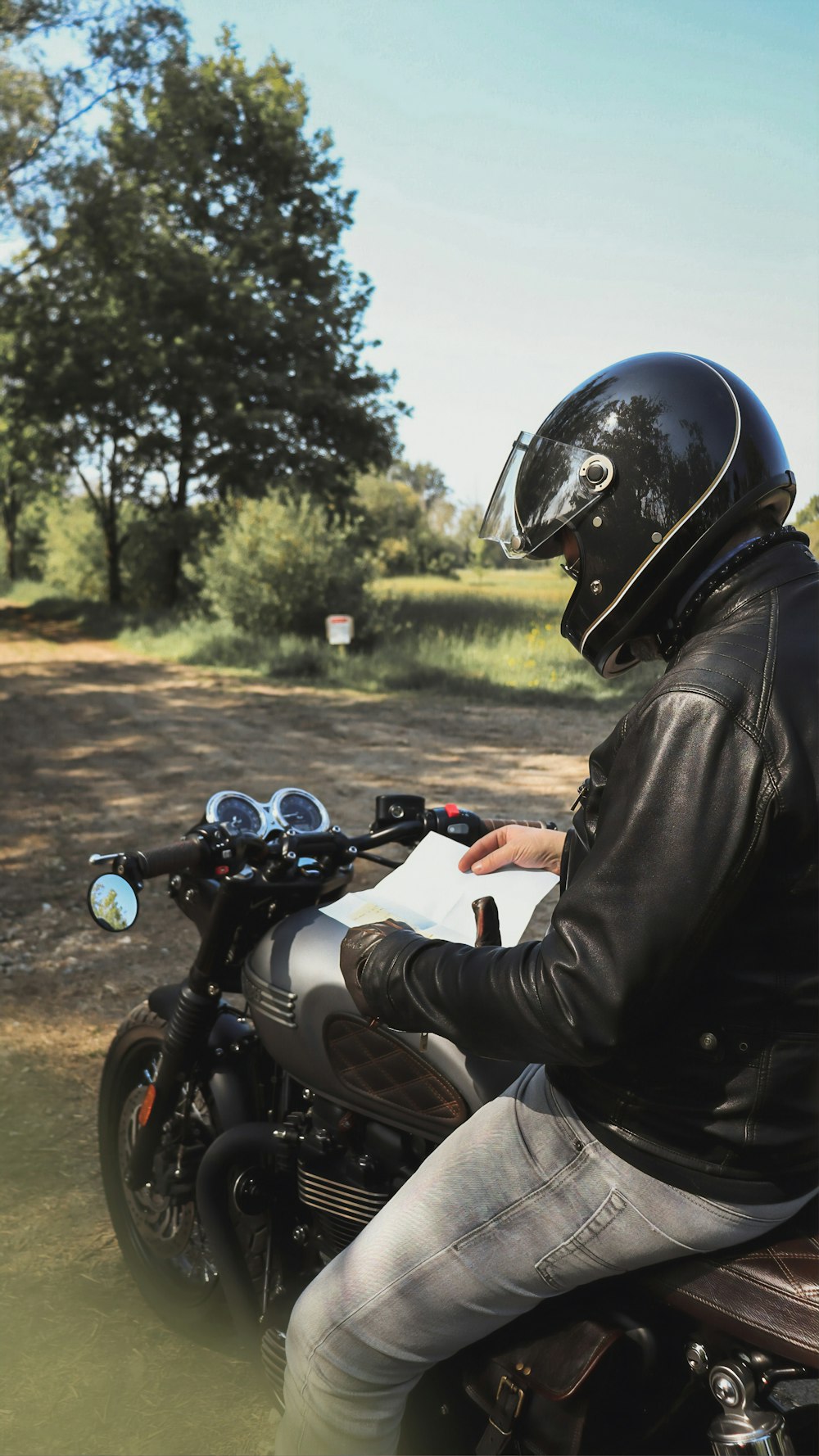 man in black leather jacket riding motorcycle during daytime