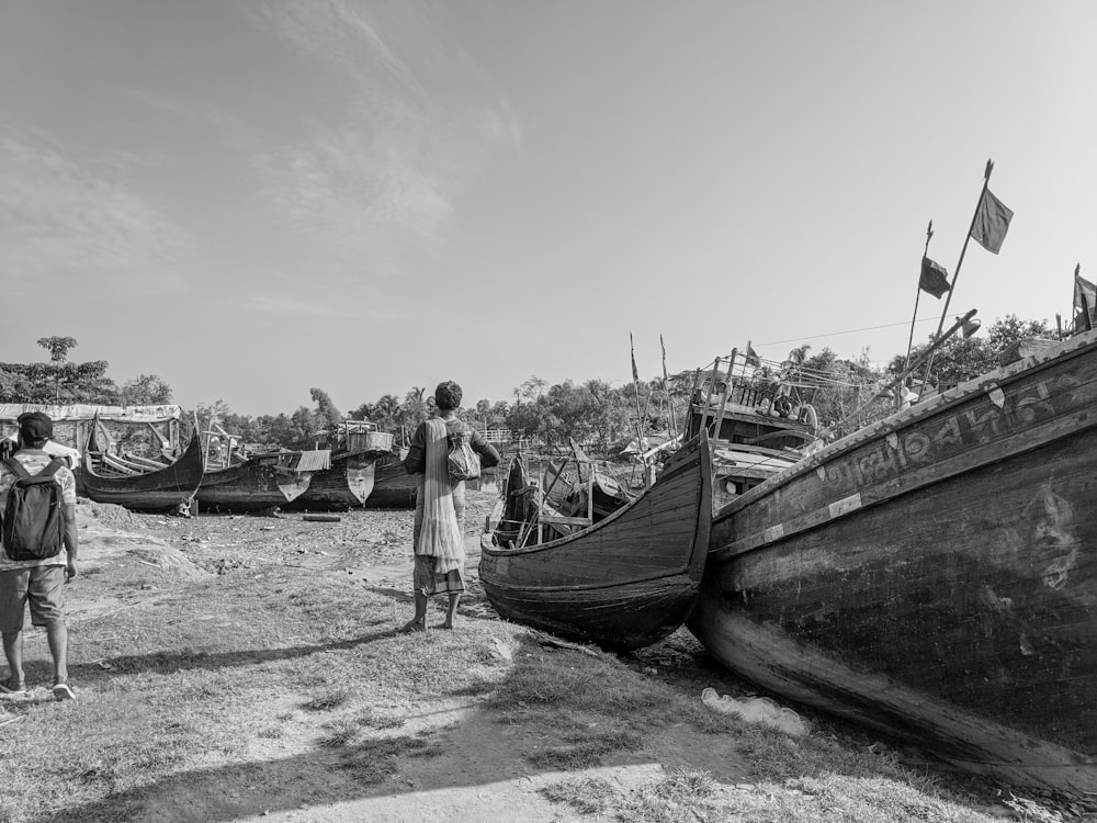 grayscale photo of people standing on boat