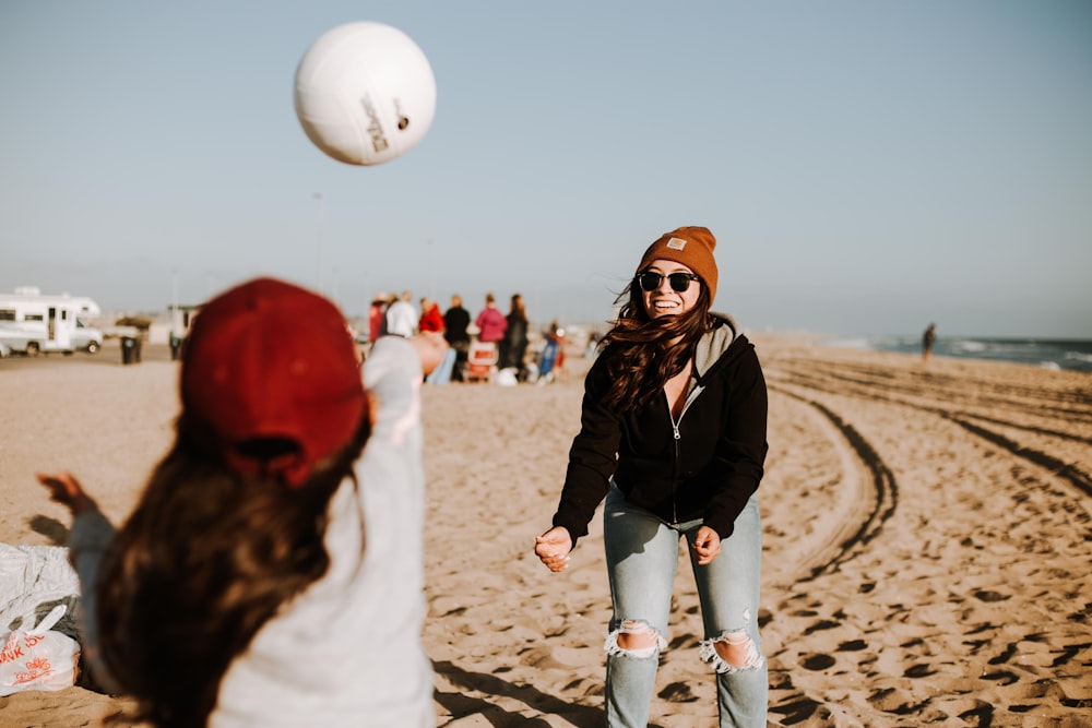 woman in black jacket and white pants holding white volleyball