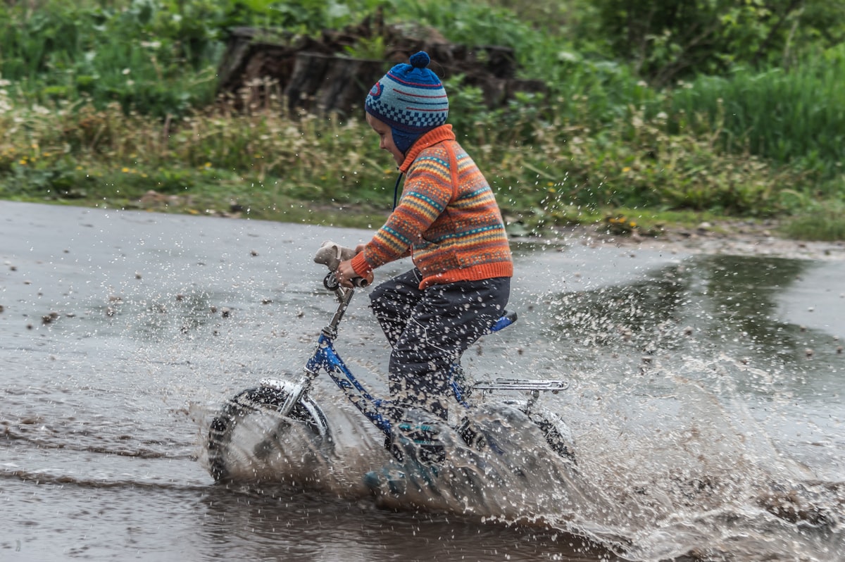 Child riding bicycle away from camera