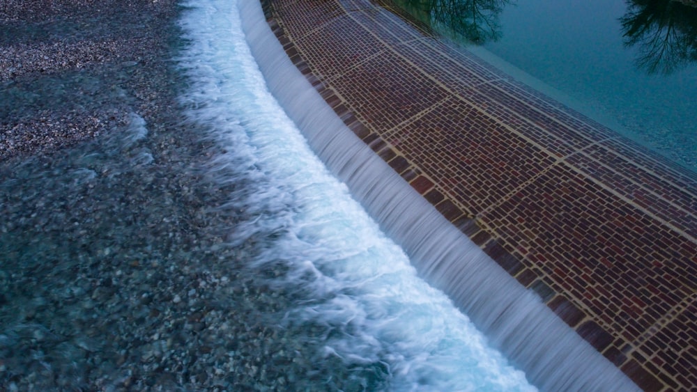 water falls on brown wooden fence