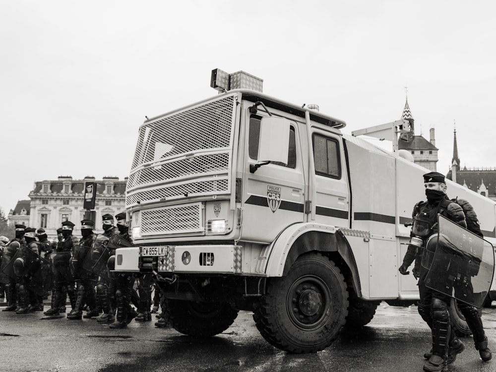 group of men standing beside white truck