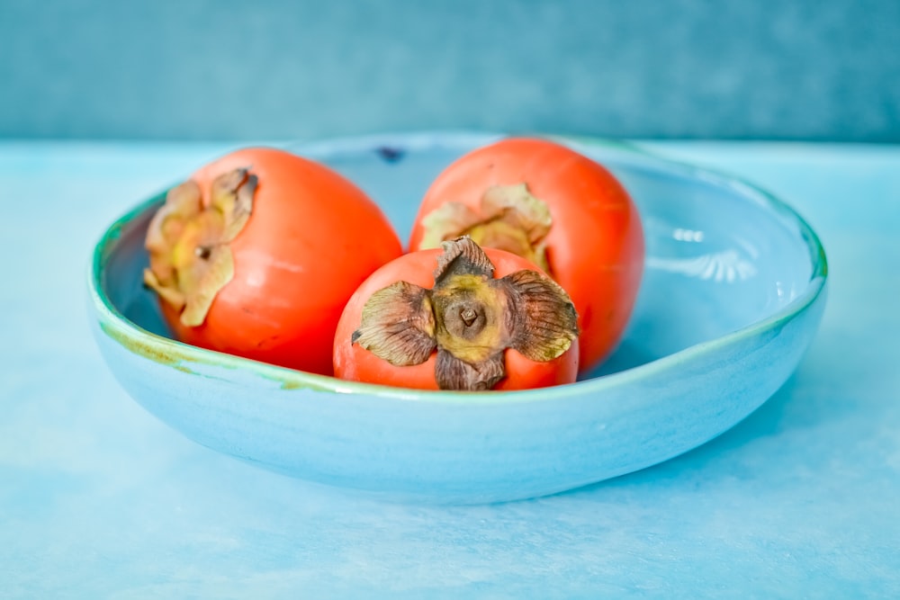 red tomato on blue ceramic bowl