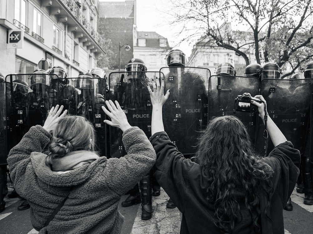 Photo en niveaux de gris d’une femme en pull tenant un smartphone