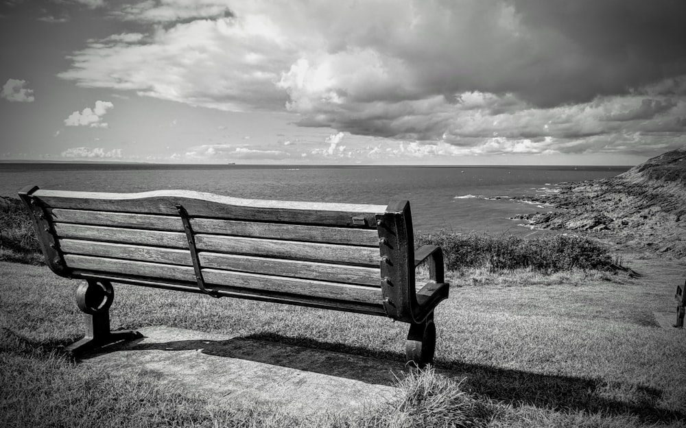 grayscale photo of bench on field