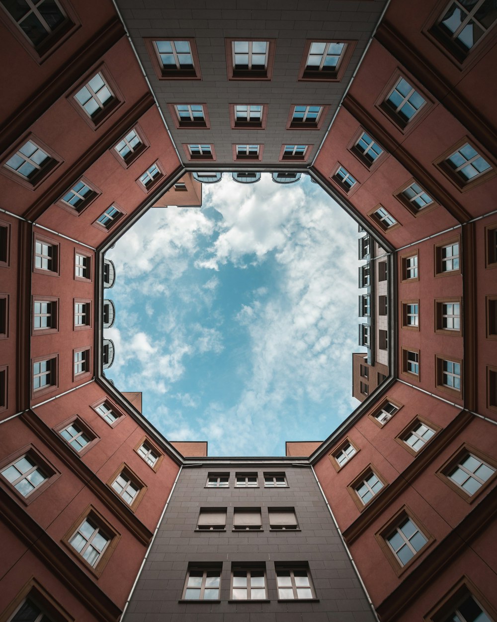 brown concrete building under white clouds and blue sky during daytime
