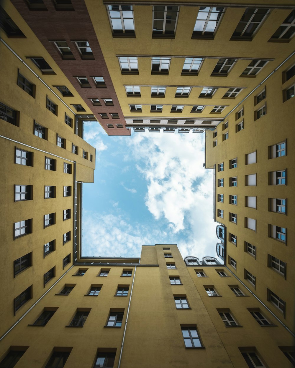 brown concrete building under blue sky and white clouds during daytime