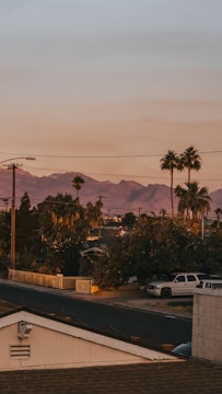 A technician installing fiber optic cables in a suburban neighborhood at sunset.