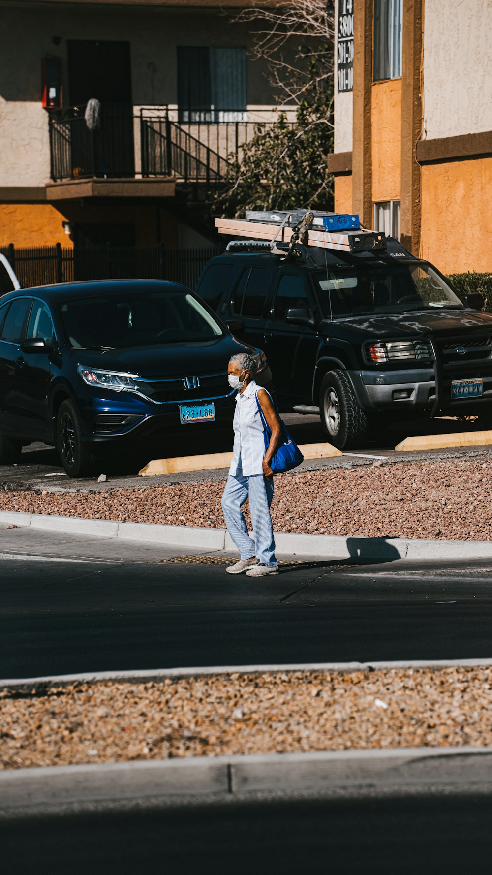 man in gray shirt and pants standing beside black honda car