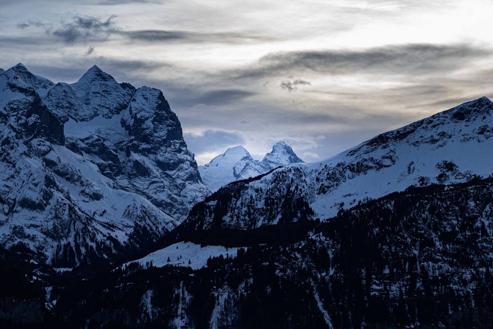 snow covered mountain under cloudy sky during daytime