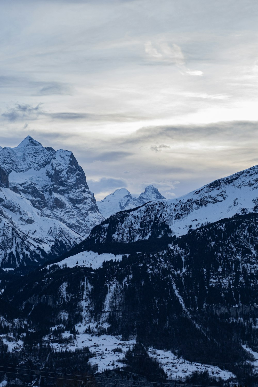 montanha coberta de neve sob céu nublado durante o dia