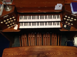 brown wooden upright piano with black and white piano keys