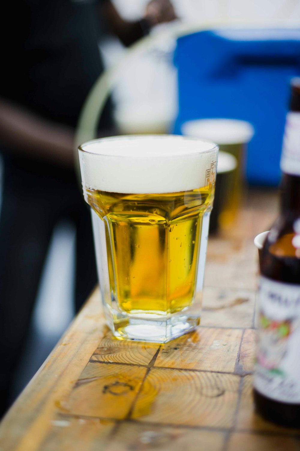 clear drinking glass with yellow liquid on brown wooden table