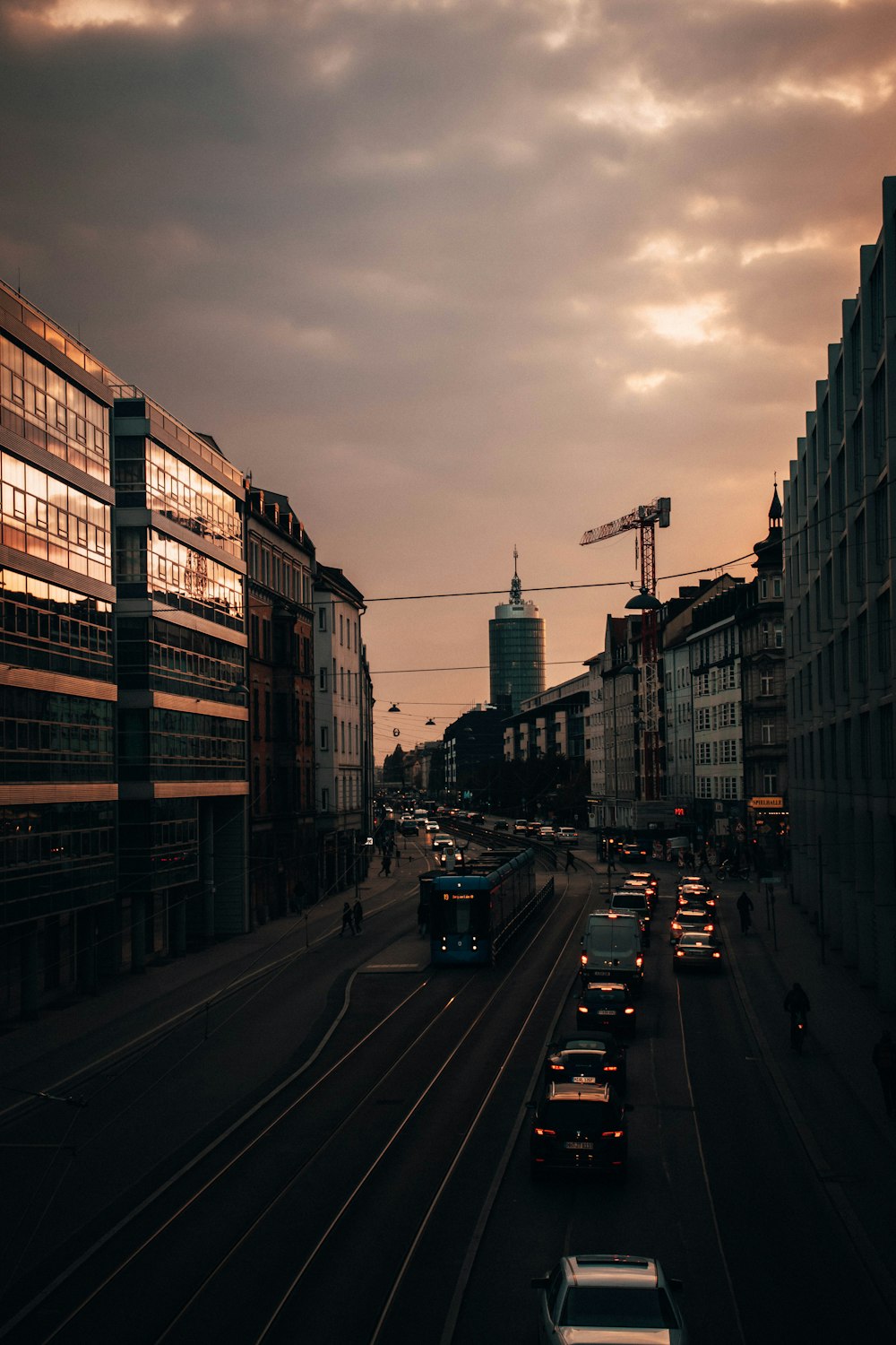 cars on road between high rise buildings during daytime