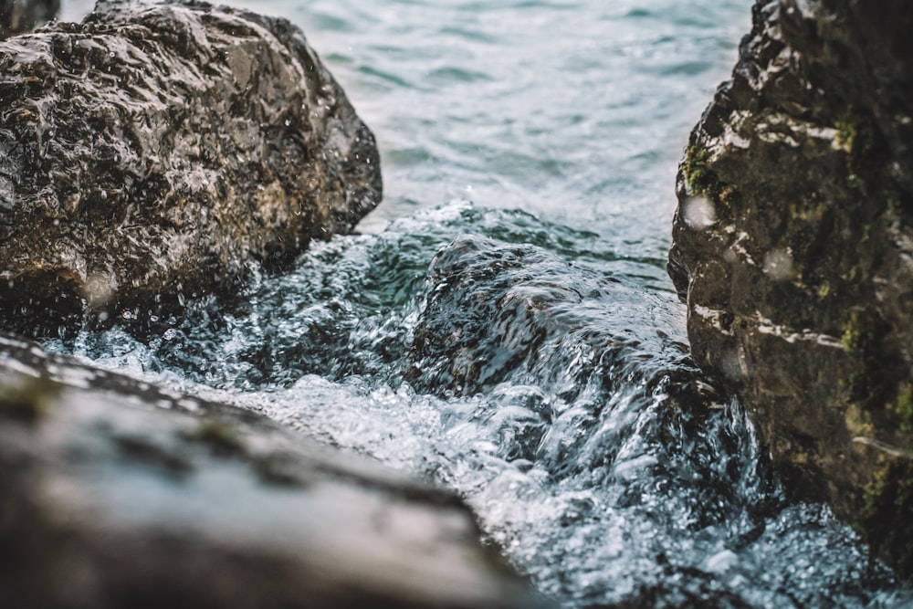 formação rochosa cinzenta ao lado do corpo de água durante o dia