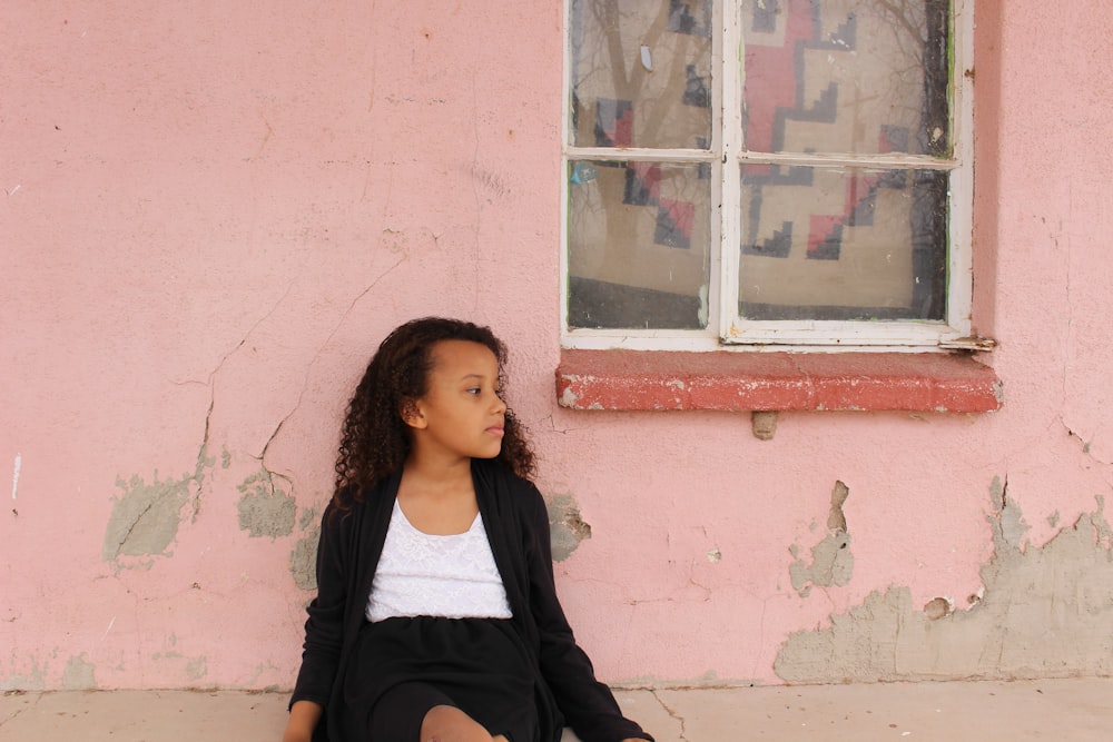 woman in black cardigan sitting on brown wooden bench