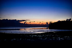 A cinematic frame of a quiet moment by the ocean at twilight, with deep shadows and rich colors