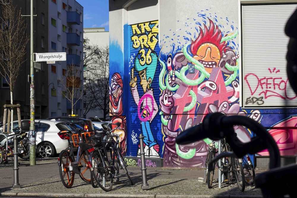 man riding bicycle near wall with graffiti