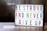 A lightbox with colorful letters displays the motivational message: 'Be Strong and Never Give Up'. The letters are in vibrant colors including green, magenta, and yellow, arranged across three lines. The background is softly blurred, giving a cozy and warm appearance.