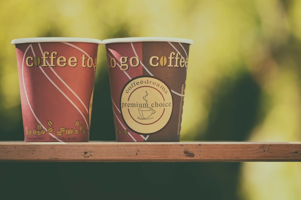 Two cardboard coffee cups, 4oz and 8oz, side by side showcasing custom printed artwork.